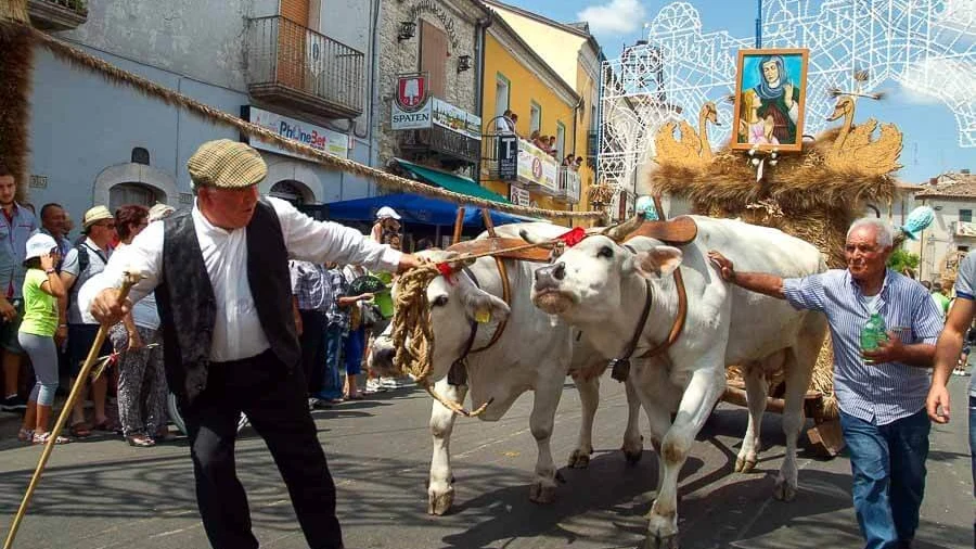 Visitatori passeggiano tra le vie di un borgo durante un festival enogastronomico estivo