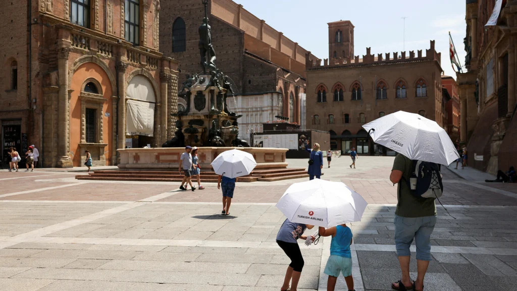 Persone che si proteggono dal sole in una città italiana durante il picco delle temperature