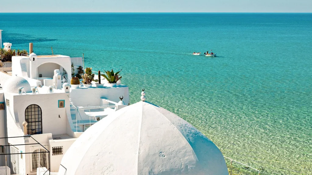 Spiaggia mediterranea e resort durante le vacanze estive 2026 tra Grecia, Spagna e Portogallo