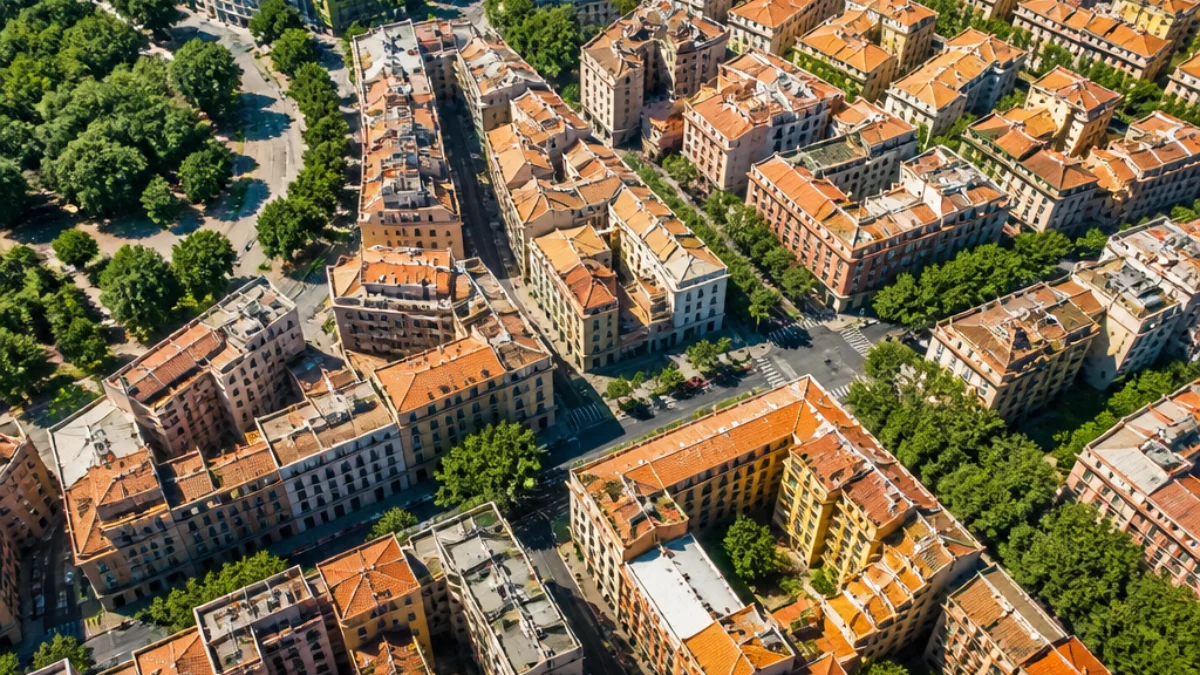 Vista urbana estiva con tetti, asfalto e aree verdi riscaldati dal sole